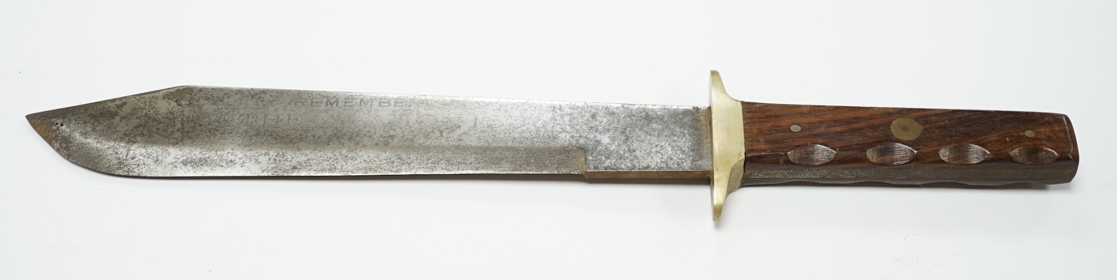 A Bowie knife with swollen blade, etched ‘Remember the Alamo 1836 the last stand of Col. Jim Bowie’, brass cross piece, riveted rosewood grips, blade length 27.5cm. Condition - fair